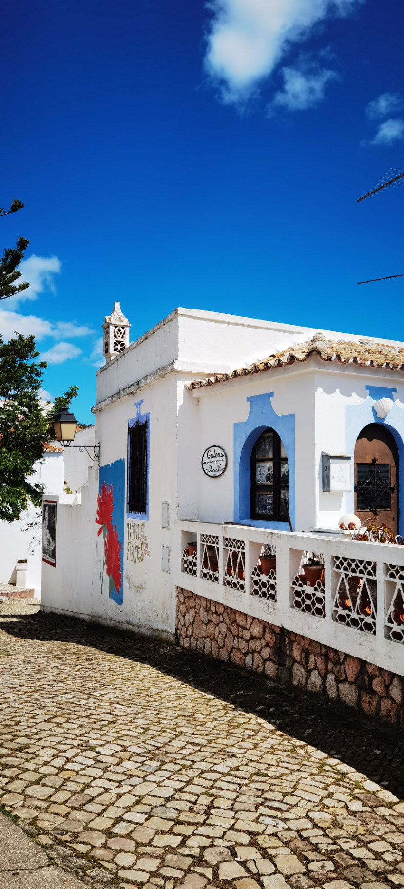Rue pavée et maison blanche dans un village typique de l’Algarve