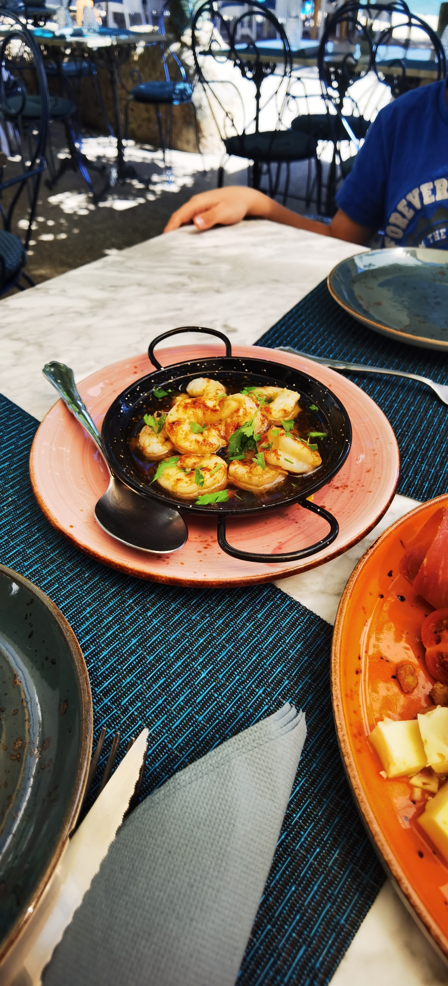Gambas al ajillo servies dans une poêle en terrasse à Majorque